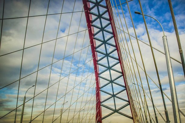 Piękne tło i widok, krajobraz i panorama nowoczesny wantowy łukowe typu, Czerwony most przeciw błękitne niebo z chmurami. - Zdjęcie, obraz