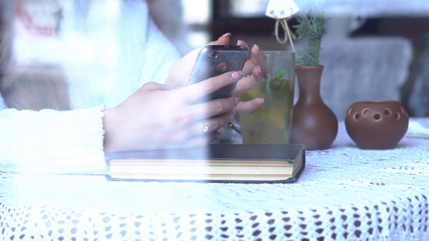 Beautiful Girl Using Phone While Drinking Coffee In A Cafe Viewed Through Window - Filmati, video