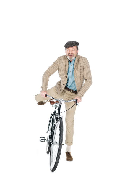 cheerful pensioner smiling while riding bicycle isolated on white - Фото, изображение