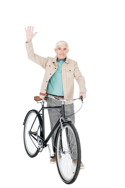 cheerful retired man holding bike and waving hand isolated on white - Zdjęcie, obraz
