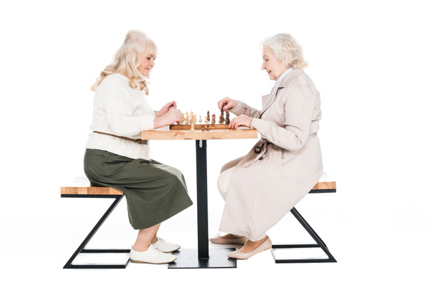 cheerful senior women playing chess isolated on white - 写真・画像