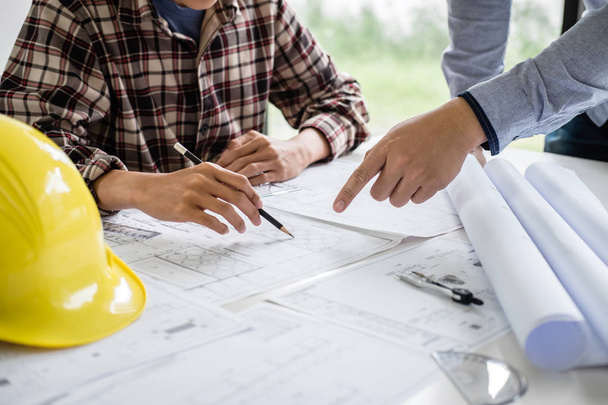 Construction engineering or architect discuss a blueprint while checking information on drawing and sketching meeting for architectural project in work site. - Photo, Image
