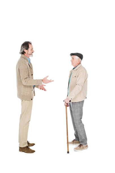 白で隔離肩コリと立っている友人と話している引退した男性  - 写真・画像