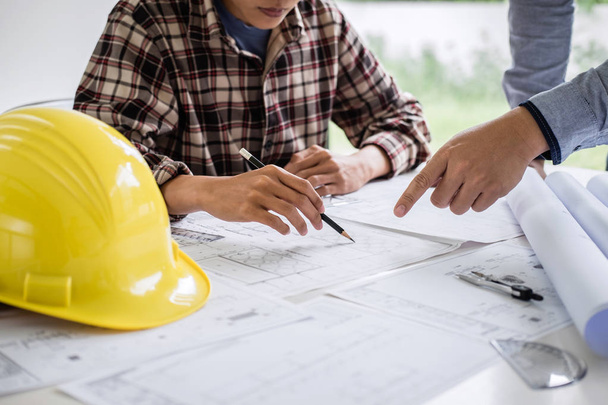 Construction engineering or architect discuss a blueprint while checking information on drawing and sketching meeting for architectural project in work site. - Photo, Image