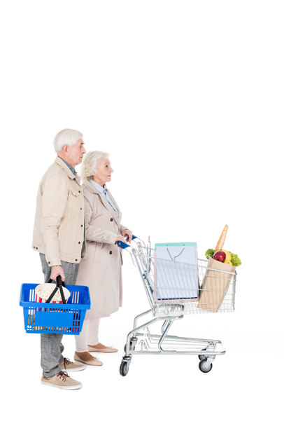 retired husband and wife walking with shopping trolley and basket isolated on white - Photo, Image