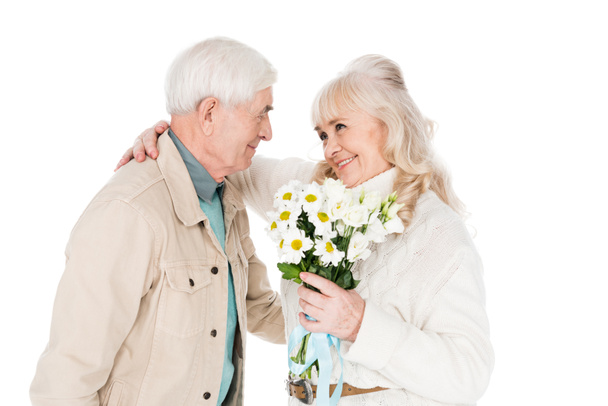 homme âgé joyeux donnant des fleurs à femme heureuse isolé sur blanc
 - Photo, image