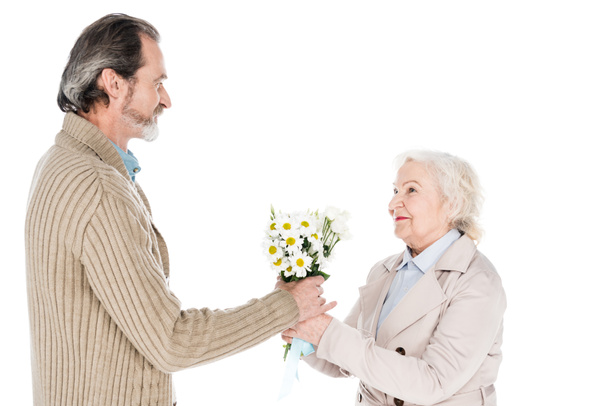 alegre hombre mayor dando flores a la mujer feliz aislado en blanco
 - Foto, Imagen