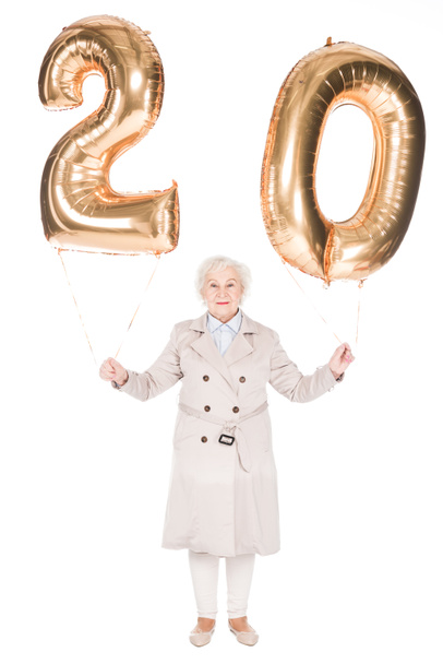 улыбающаяся пожилая женщина держит воздушные шары изолированы на белом
 - Фото, изображение