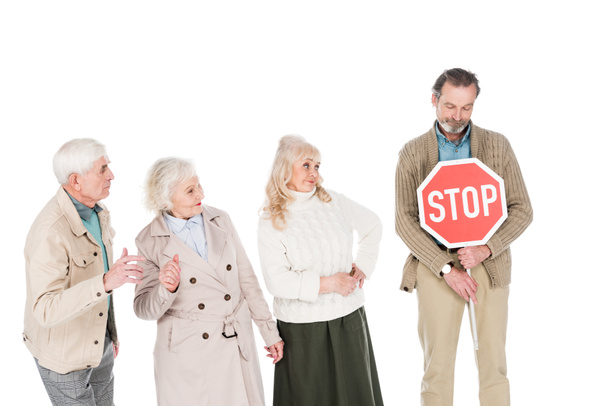 retired people looking at senior man holding stop sign in hands isolated on white - 写真・画像