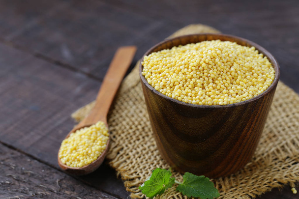 millet groats in a wooden cup, healthy food - Photo, Image