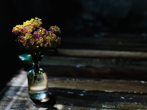素朴な木製のテーブルにガラスの瓶に葉美しいランタナカマラまたはグリーンとゴールドの花の布 - 写真・画像