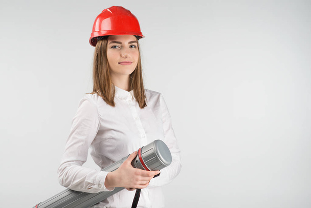 Smiling woman  stands  in orange helmet holds tube closeup - Photo, Image