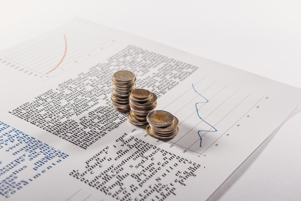selective focus of coins stacks on document with graph - 写真・画像