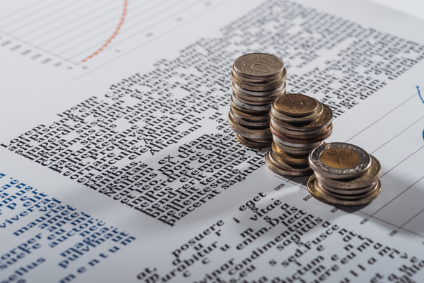 selective focus of coins stacks on text document with graphs - Photo, Image