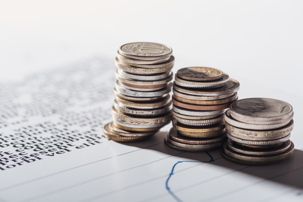 selective focus of coins stacks on document with graphs and blurred background - Foto, Imagem