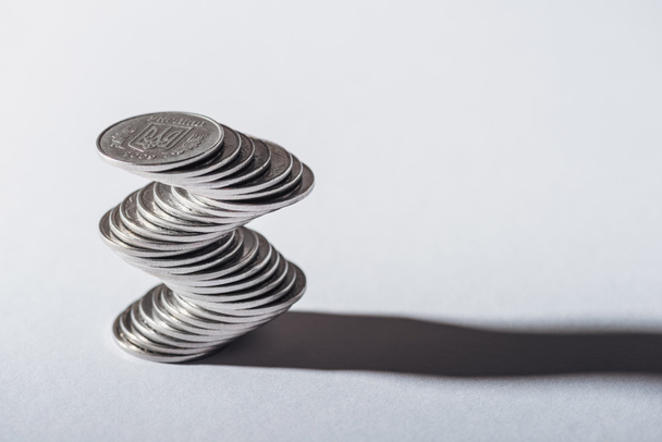 стопка серебряных монет и тени на сером фоне
 - Фото, изображение