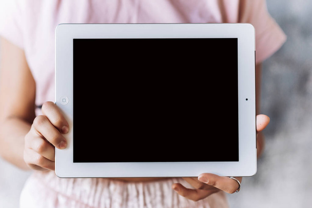 Closeup of ipad  in the center in female hands, blurred background - Фото, изображение