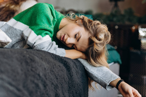 Portrait rapproché d'une femme blonde endormie dans un pull vert
 - Photo, image