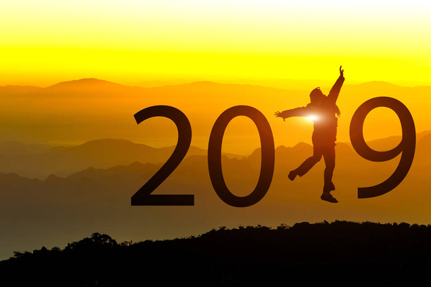 Silhueta da liberdade feliz jovem saltando na colina com o conceito de Ano Novo 2019 no fundo do pôr do sol
. - Foto, Imagem