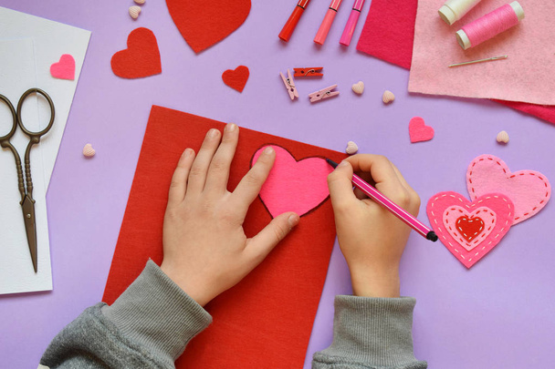 Making of handmade Valentine greeting card from felt. Children's DIY, hobby concept, gift with your own hands. Valentine's Day decoration. Step 1. Circle the heart template. - Photo, Image