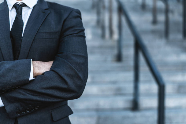 Close-up zakenman kruising zijn handen tegen de achtergrond van de office-trap poseren achtergrond wazig. - Foto, afbeelding