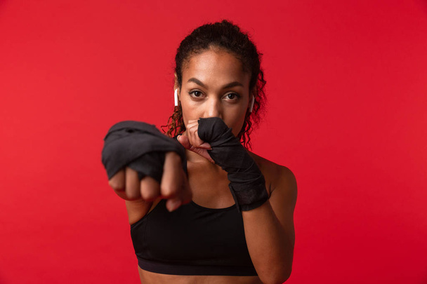 Fekete sportruházat Box sport kötszerek a kezét, elszigetelt, felett piros háttér-súlyos afrikai-amerikai nő portréja - Fotó, kép