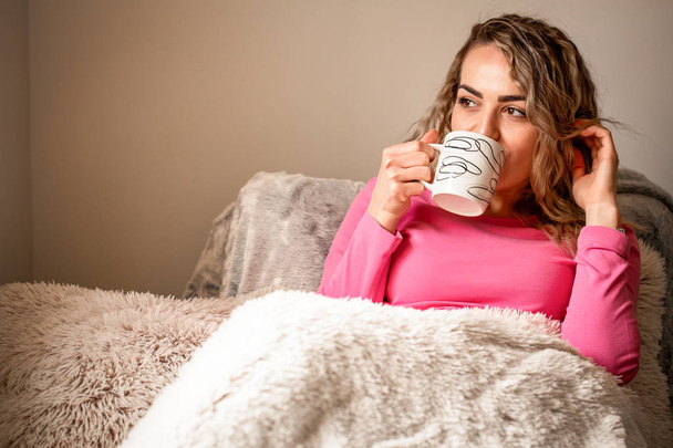 Relaxed woman drink coffee on a comfortable couch at home - Foto, afbeelding