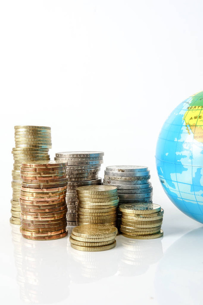 Conceito de economia global com globo de esfera e empilhado de moedas sobre branco
. - Foto, Imagem