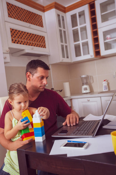 Multitasking junger Vater ist Babysitter und arbeitet zu Hause - Foto, Bild