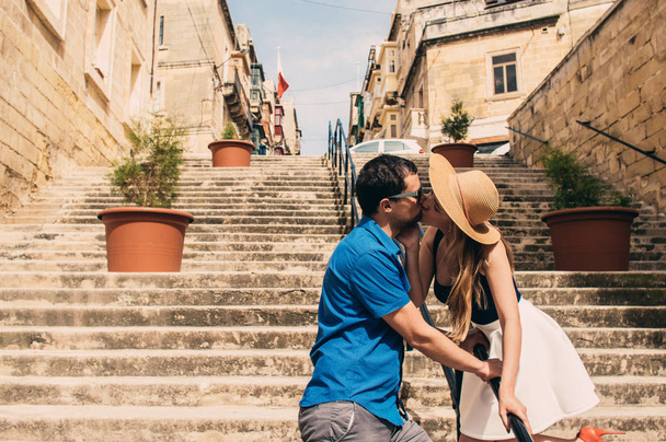 Mann und Frau gehen und küssen sich auf der Treppe auf der Straße, Altstadt der drei Städte, Malta - Foto, Bild
