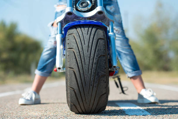 Girl biker riding a motorbike on an asphalt road. - Fotó, kép