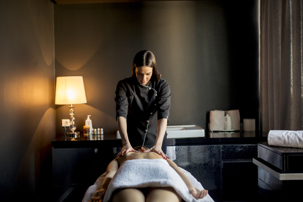 Молода жінка має масаж в оздоровчому центрі
 - Фото, зображення