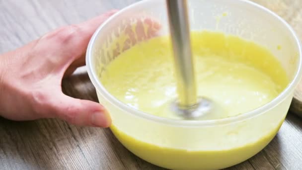 close-up whipping homemade mayonnaise with a blender in a plastic bowl - Video, Çekim