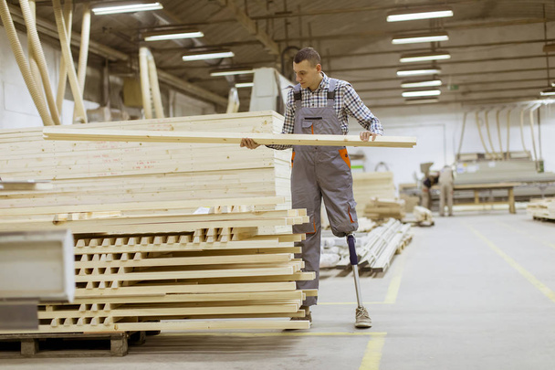 На меблевій фабриці працює молодий чоловік з штучною ногою
 - Фото, зображення