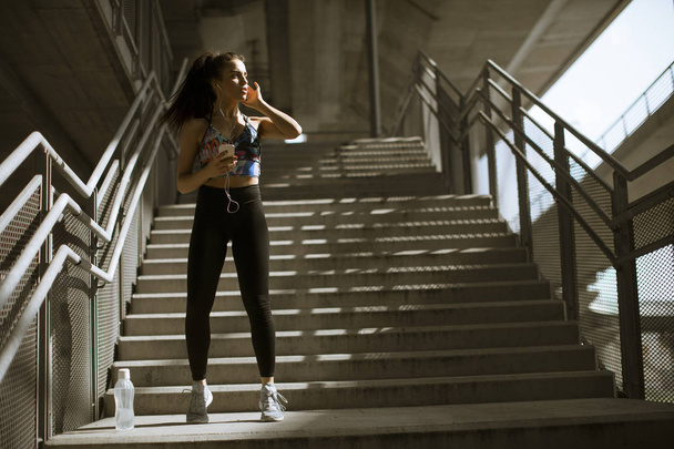 junge Fitness-Frau macht Übungen im Freien in urbaner Umgebung - Foto, Bild