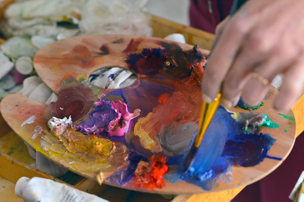 image recadrée d'un artiste gaucher prenant de la peinture dans une palette en atelier
 - Photo, image