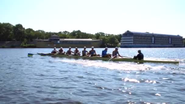 Equipo de remo entrenamiento de verano. 8 atletas reman en un bote en el río Dnipro. Zona de la ciudad en Kiev, Ucrania - Imágenes, Vídeo