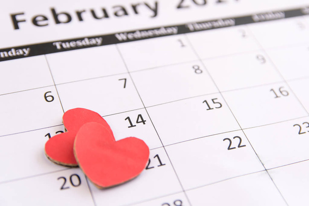 Página de calendário e papel de corações vermelhos no dia 14 de fevereiro do dia dos namorados
. - Foto, Imagem