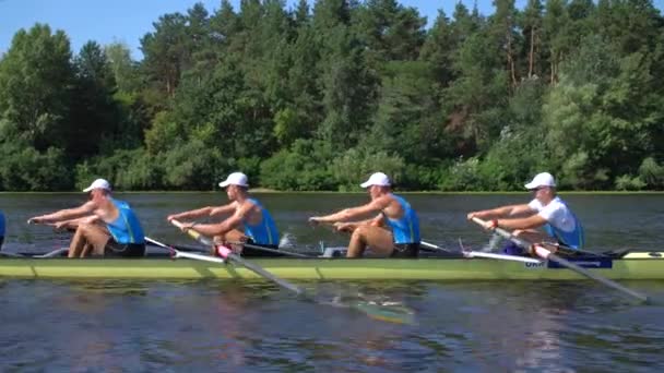 Evezős csapat nyári tréning. 8 sportoló evez egy csónakban a Dnipro folyóban. Városi terület Kijevben, Ukrajna - Felvétel, videó