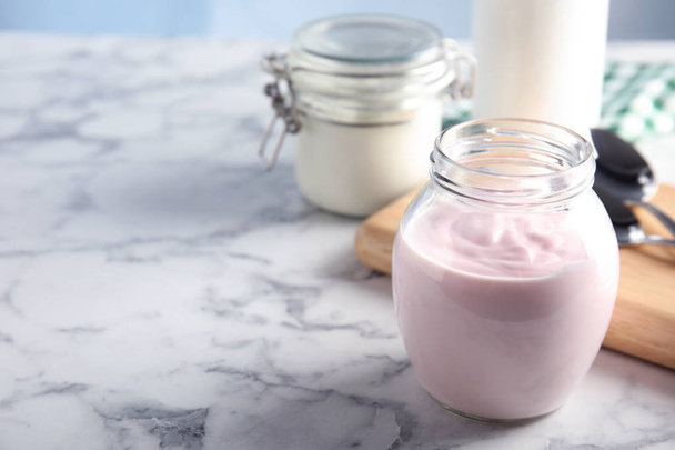 Glass jar of fresh yogurt on table. Space for text - Foto, Bild