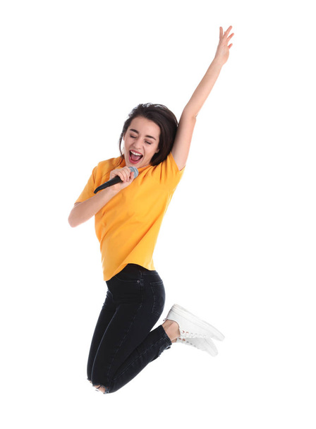Young woman wearing casual clothes singing in microphone on white background - Фото, изображение