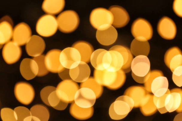 Beautiful golden lights on dark background. Bokeh effect - Foto, imagen
