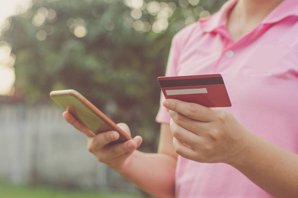 Adam el kredi kartı tutan ve online ödeme online, online alışveriş yapma akıllı telefon kullanma - Fotoğraf, Görsel