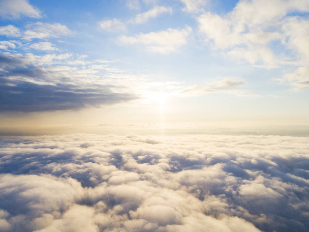 Aerial view White clouds in blue sky. Top view. View from drone. Aerial bird's eye view. Aerial top view cloudscape. Texture of clouds. View from above. Sunrise or sunset over clouds - Фото, изображение