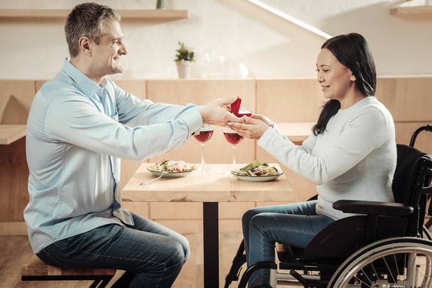 Cheerful man making a surprise to his disabled wife - Foto, afbeelding