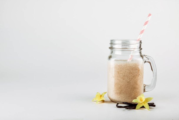 Protein cocktail with milk, vanilla in a glass jar with straws. Sports nutrition - Φωτογραφία, εικόνα
