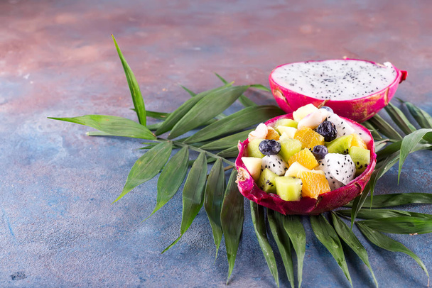 Tropikal meyve salatası hizmet bir taş zemin üzerine yarım Papaya Dragon meyve. - Fotoğraf, Görsel