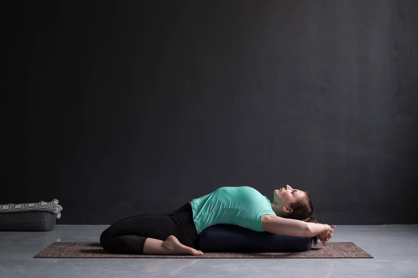 Yoga supta virasana asana bolster kullanarak yapıyor güzel atletik kız - Fotoğraf, Görsel