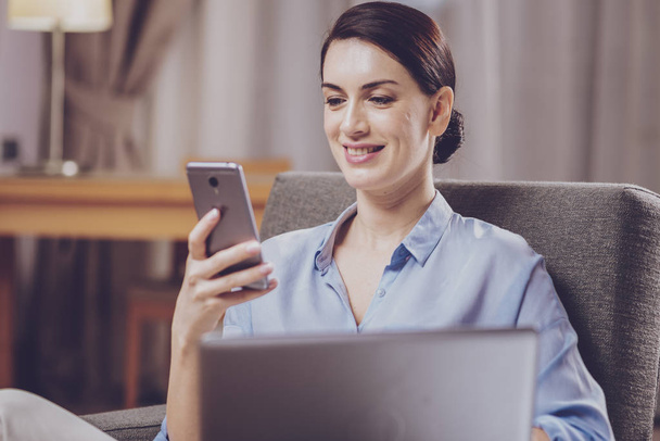 Pleasant woman looking at smartphone screen - Photo, image