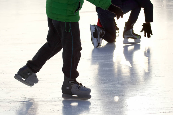 piedi di persone diverse che pattinano sulla pista di ghiaccio
 - Foto, immagini